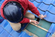 屋根の問題をカメラで記録する作業員